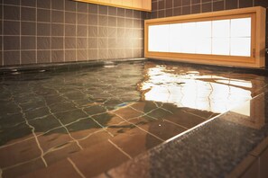 Ein Whirlpool mit gefliestem Boden und einem Holzrahmen um das Fenster.