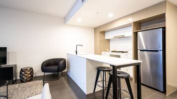 Una cocina moderna con una isla central, electrodomésticos de acero inoxidable y un diseño minimalista.