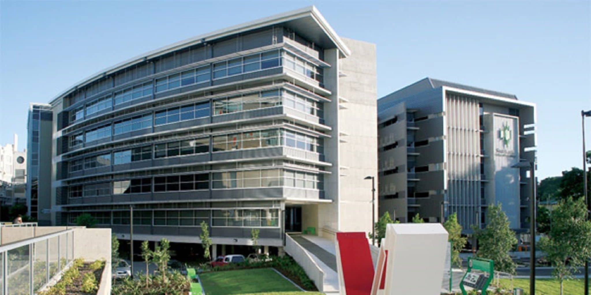 A modern multi-story building with large windows and a flat roof.