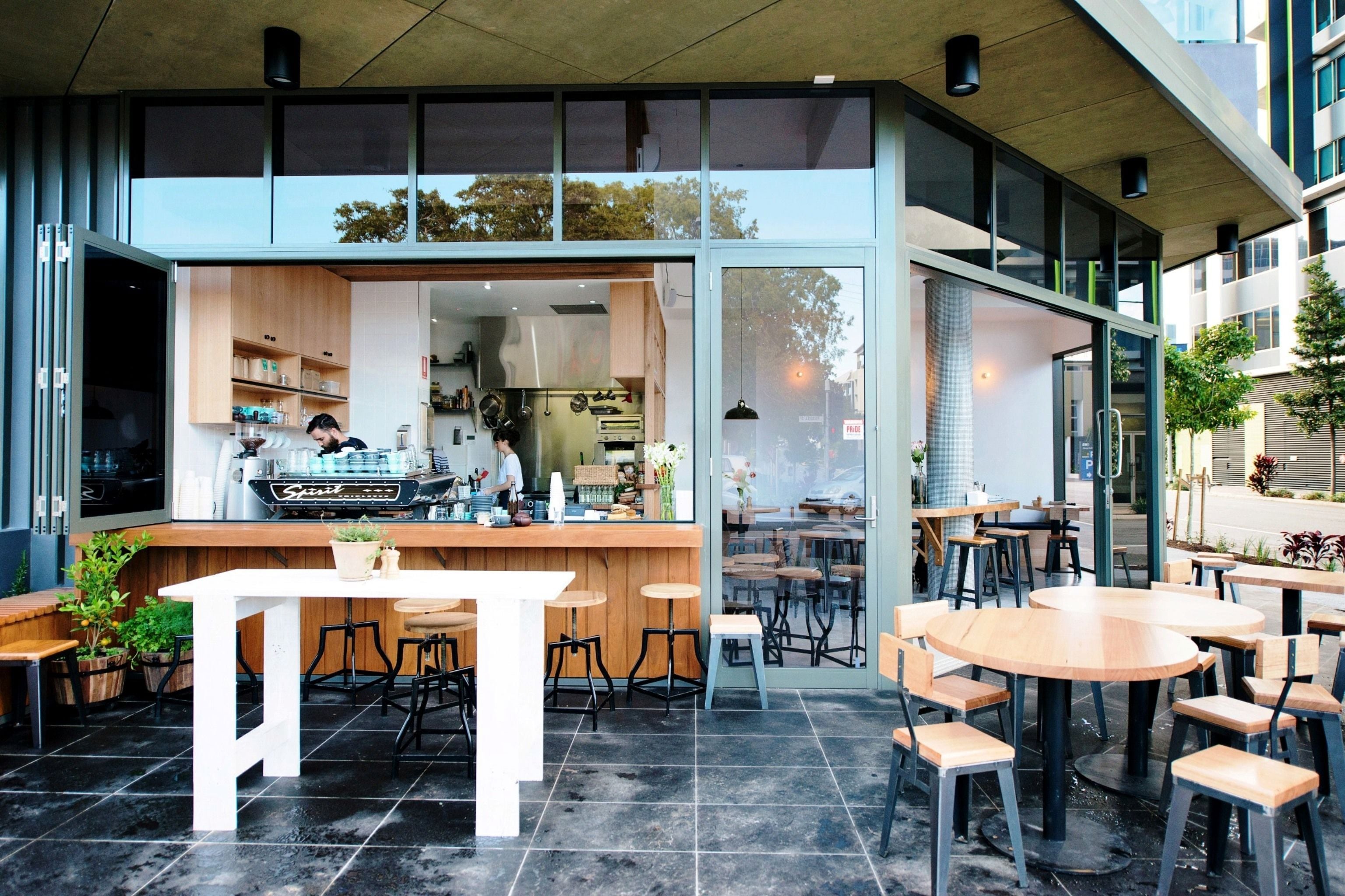 Ein Straßencafé mit Bar, Sitzgelegenheiten und Blick auf die Straße.