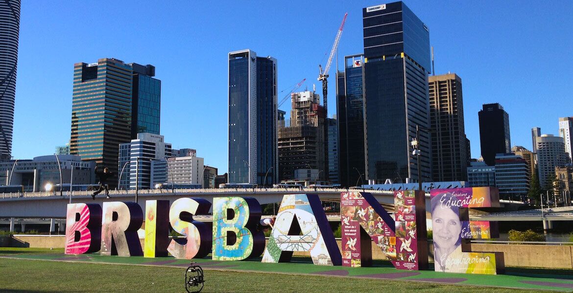 A cityscape with the word "BRISBANE" prominently displayed in the foreground.