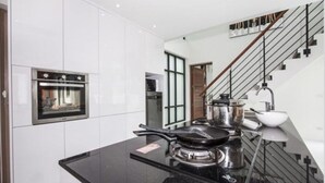 Una cucina moderna con forno integrato, piano cottura e lavello.