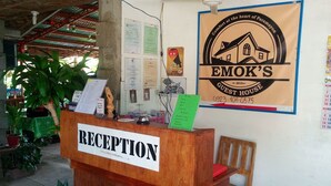 A reception desk labeled "RECEPTION" with a signboard for "EMOK'S GUEST HOUSE" and a phone number. - Emok's Guest House - Hostel (Moalboal)