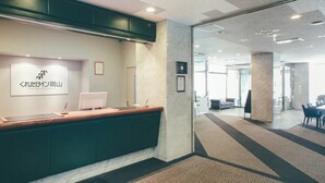A reception desk with a computer, a framed certificate, and a sign reading "Kuretake Inn Okayama". - Kuretake Inn Okayama (Okayama)