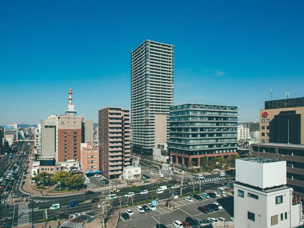 A cityscape with modern buildings, a busy intersection, and a clear sky.