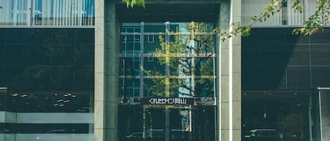 A building entrance with a glass facade and a sign above the doors.
