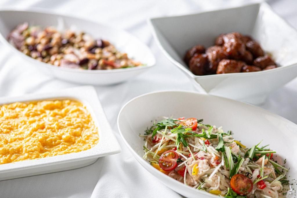 Trois assiettes blanches contenant différents types d’aliments.