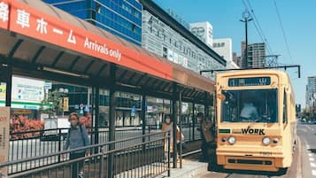 A bus stop with a shelter and a bus labeled 'Town Work' approaching.