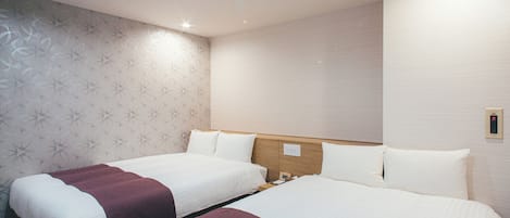 A hotel room with two beds, a wooden headboard, a patterned wallpaper on one wall, and a light switch on the wall.