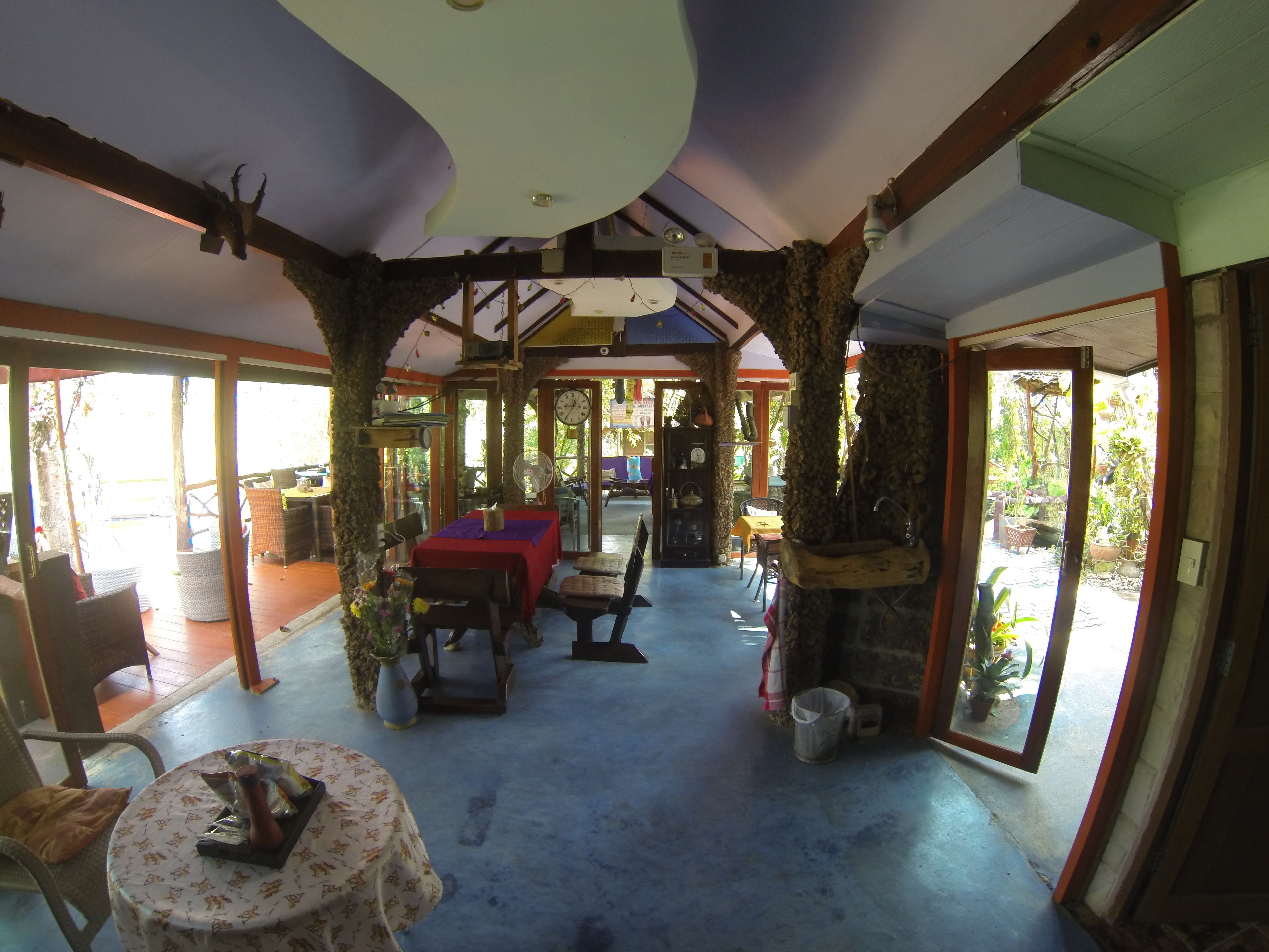 A spacious indoor area with a high ceiling, wooden beams, and a large open space with tables and chairs.