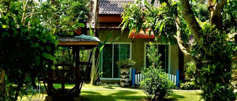 A house with a tiled roof, a small garden, and a wooden table.
