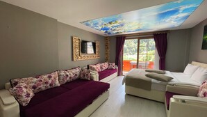 A hotel room with a sofa, a bed, a TV, and a ceiling with a sky mural. - Osmanli Suite (Çaykara)