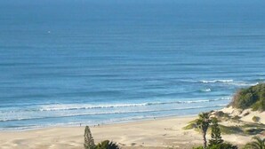 A beach with clear blue water, sandy shore, and some greenery. - Cintsa View (Great Kei)