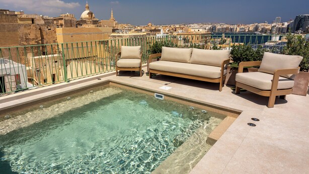 A rooftop pool area with a view of a cityscape, including a dome and buildings. - The Vincent Boutique Hotel, BW Premier Collection (Valletta)