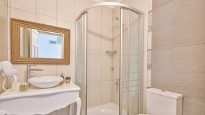 A bathroom with a white sink, a mirror with a gold frame, a shower enclosure, and a toilet. - Alacati Sorf Hotel (Cesme)