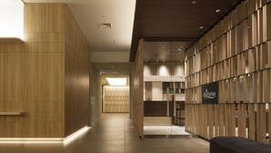 Un moderno vestíbulo de hotel con paneles de madera, una recepción y un cartel que dice 'EastWind'.