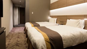 Habitación de hotel con dos camas, un televisor de pantalla plana y piso alfombrado.