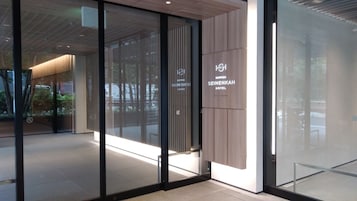 Moderni hotellin sisäänkäynti, jossa on lasiovet ja kyltti, jossa lukee Nippon Senenkan Hotel.