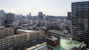 Un paisaje urbano con rascacielos, una combinación de edificios residenciales y comerciales, y un cielo despejado.