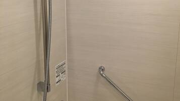 Ein Badezimmer mit Badewanne, Dusche inklusive Handbrause und einer Haltestange.