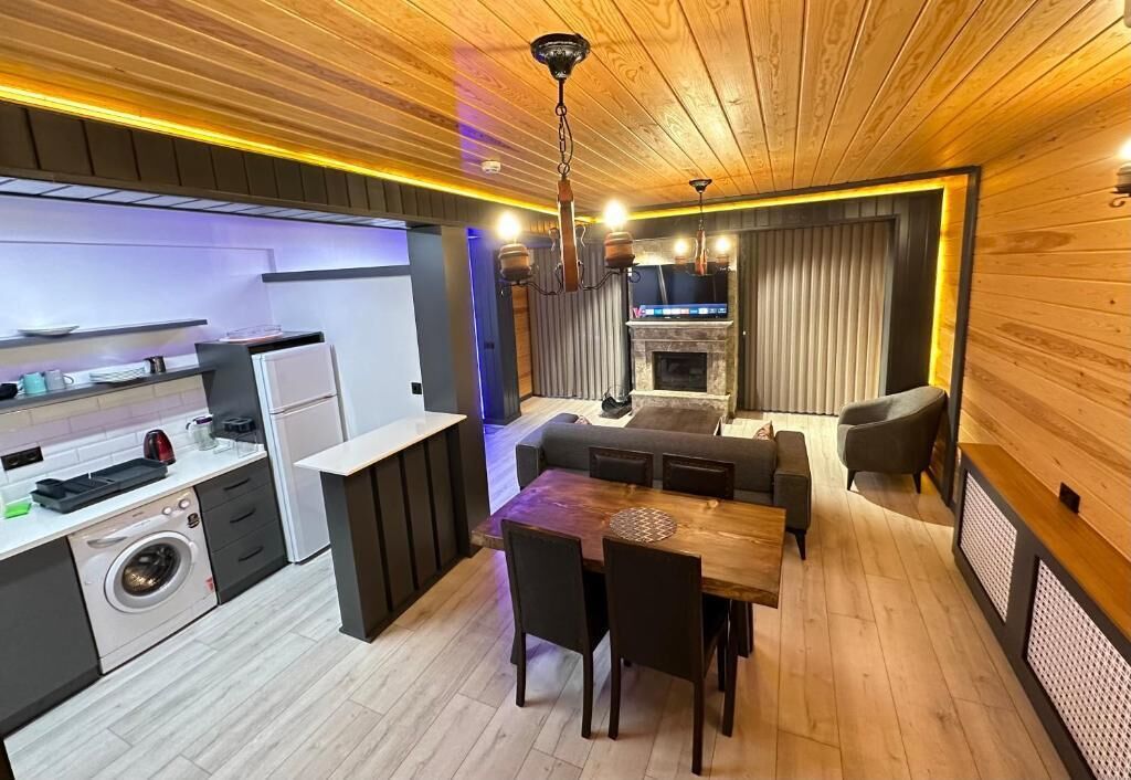 A compact living space with a kitchen, dining area, and a fireplace.