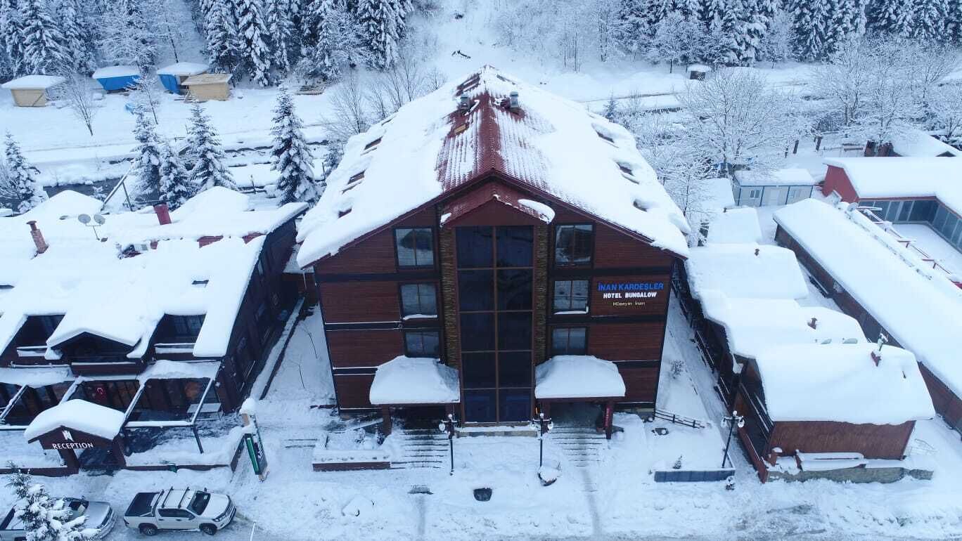 Un hotel con techo rojo y un letrero que dice "Nankardesler Hotel Bungalow".