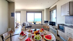 Una cocina moderna con comedor, ventanas amplias y vista al océano.
