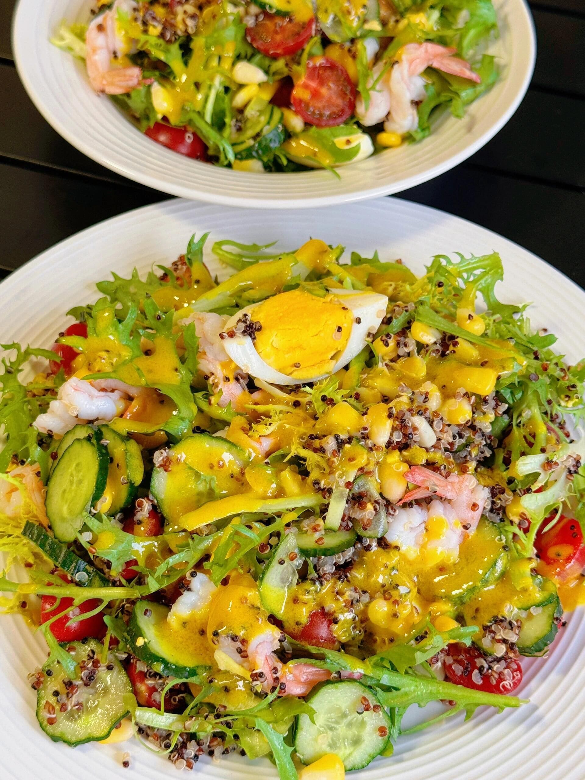 Ein Salat mit Garnelen, Eiern und verschiedenen Gemüsesorten.