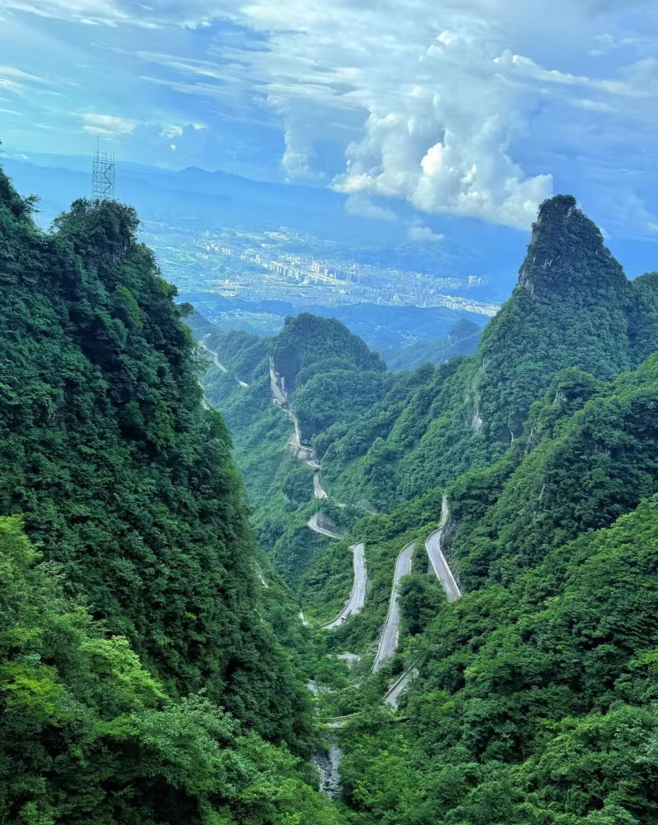 Eine gebirgige Landschaft mit kurvenreichen Straßen und dichtem Grün.