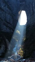 Una gran formación rocosa con un arco natural y una plataforma de observación en la base.