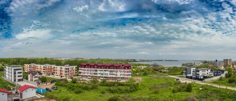 A residential area with multi-story buildings, a body of water, and a distant city skyline.
