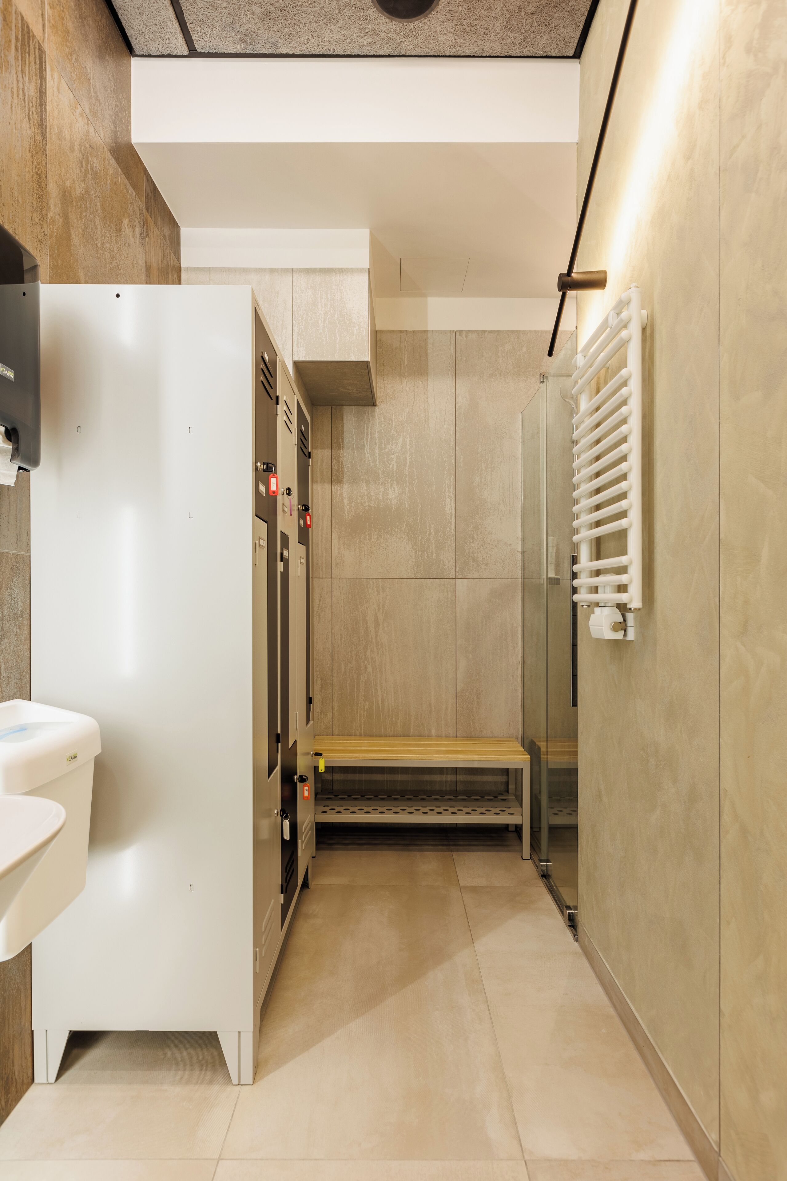Ein modernes Badezimmer mit Toilette, Waschbecken und einer Bank.