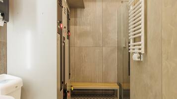 Ein modernes Badezimmer mit Toilette, Waschbecken und einer Bank.