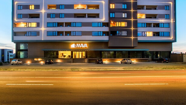 A multi-story hotel with a modern design, featuring a prominent 'MAVA' sign on the front.
