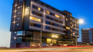 A multi-story hotel with a modern design, featuring a prominent 'MAVA' sign on the facade.