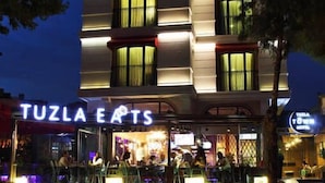 A modern building with a restaurant named 'Tuzla Eats' on the ground floor. - Tuzla Town Hotel (Tuzla)