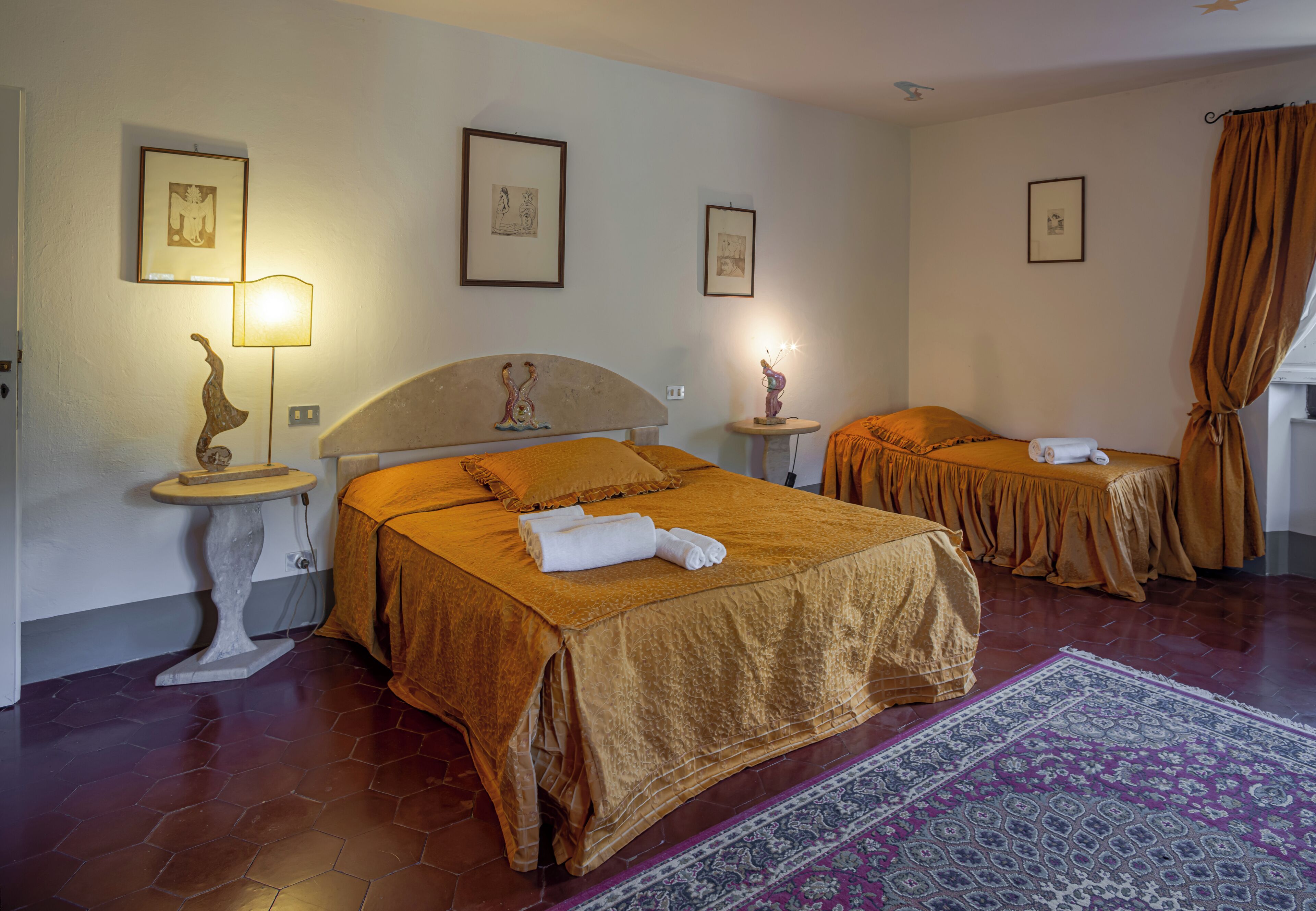 Ein Hotelzimmer mit zwei Betten, einem großen Teppich und Bildern an den Wänden.