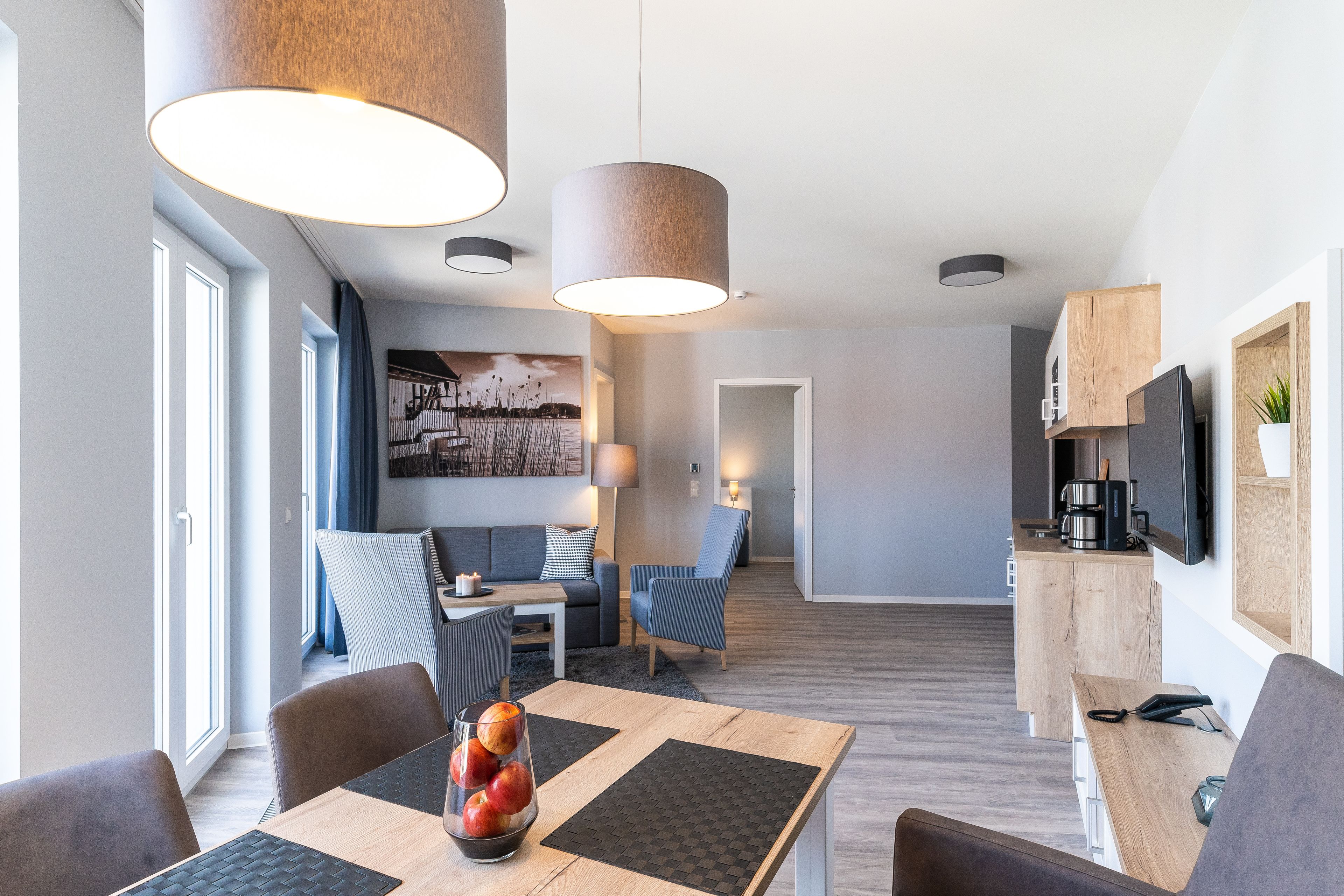 Una sala de estar moderna con comedor, cocina y un ventanal amplio.