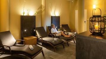 A spa area with reclining chairs, a reception desk, and a wall-mounted plant.