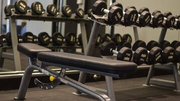 A gym with a bench and a rack of dumbbells.