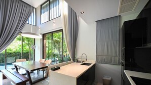 Una cocina moderna con una isla central, comedor y amplios ventanales.