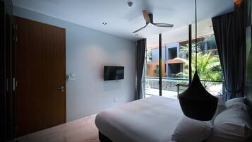A modern bedroom with a large bed, a ceiling fan, a TV, and a balcony with plants.