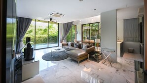 Una sala de estar moderna con un sofá seccional, una mesa de centro de vidrio y un comedor con mesa y sillas.