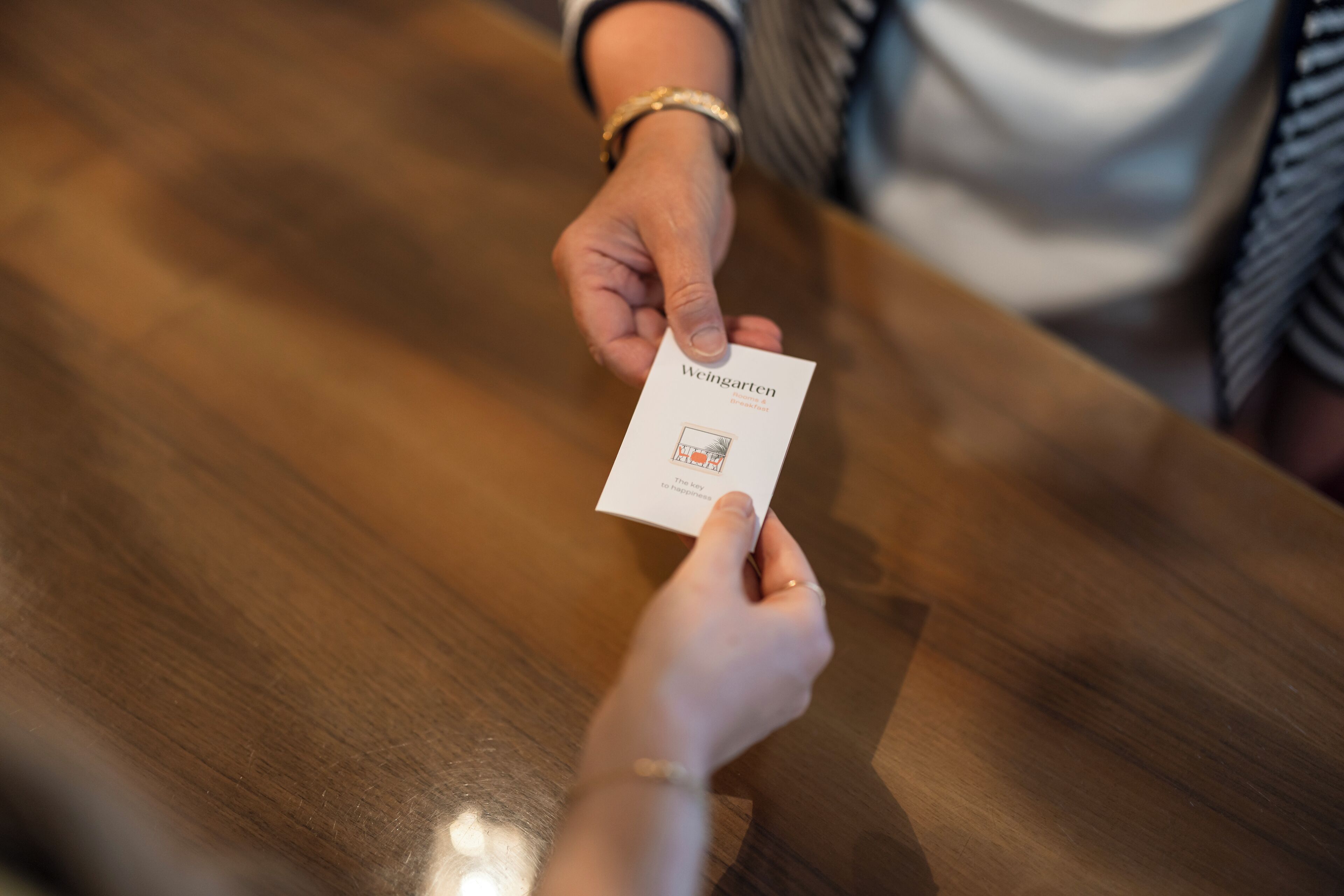 A person holding a business card with the text "Weingarten" and "The Key to Independence."