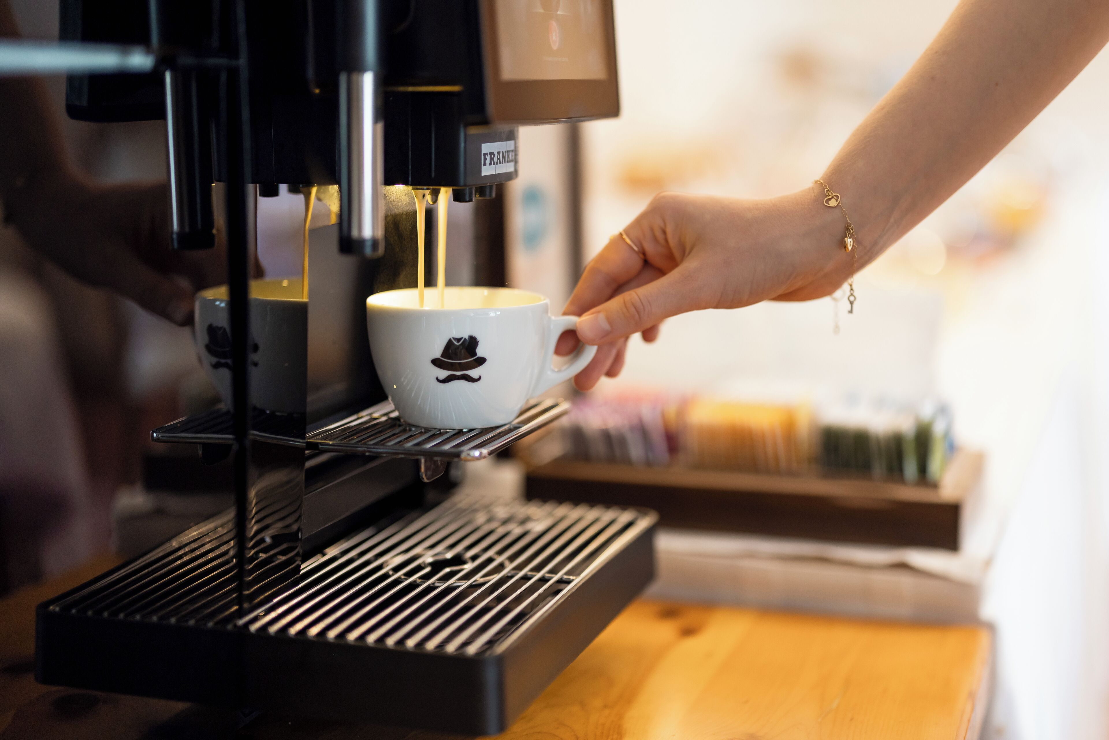 Eine Kaffeemaschine füllt eine Tasse mit Kaffee.