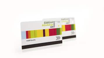 Tessera ospite per hotel con un design colorato e la scritta "Südtürlo AltoAdige PASS GUEST".