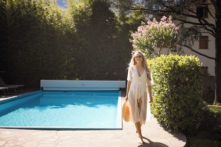 Una piscina al aire libre de temporada, sillones reclinables de piscina