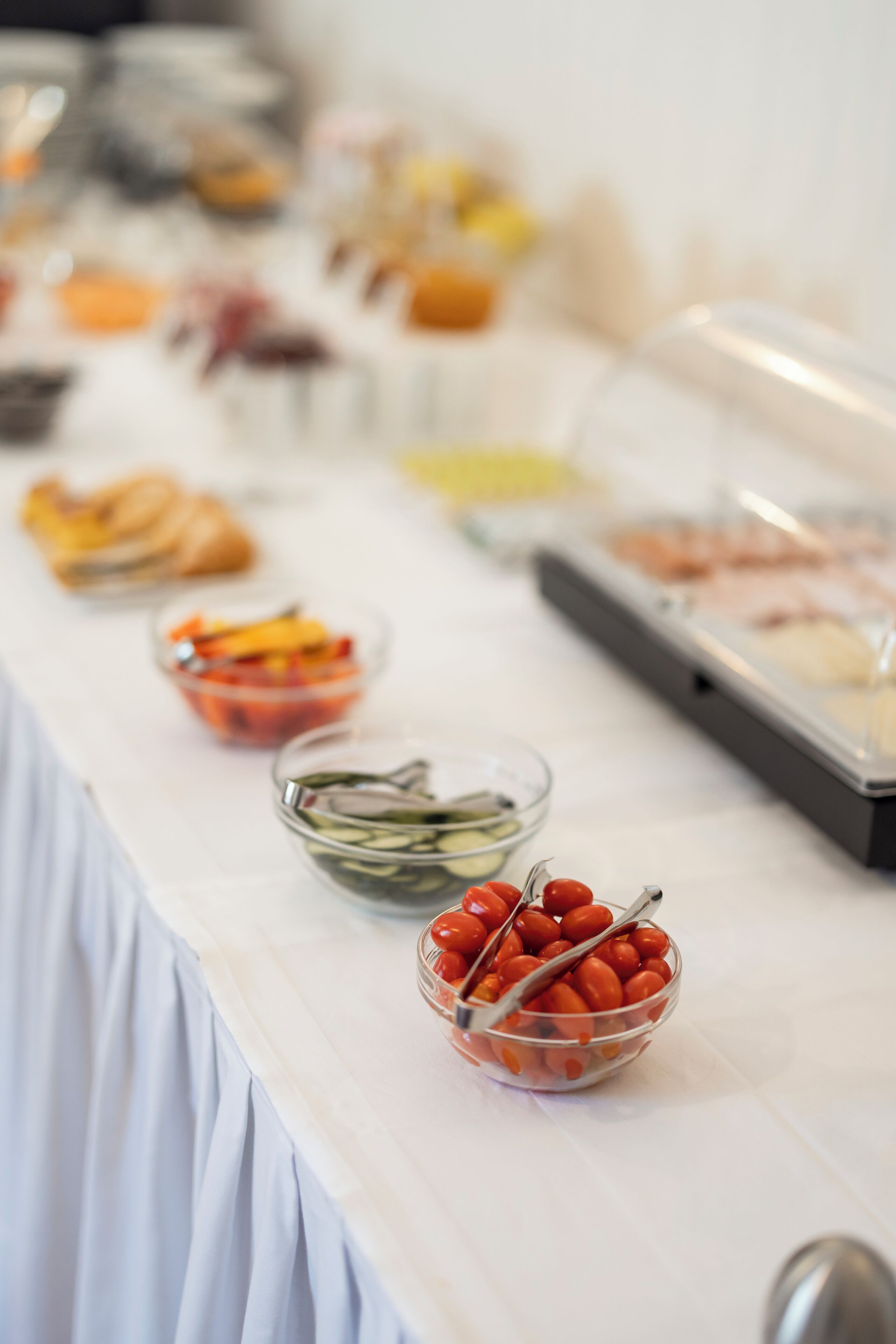 Una mesa de buffet con diversos alimentos, incluyendo frutas, verduras y carnes.