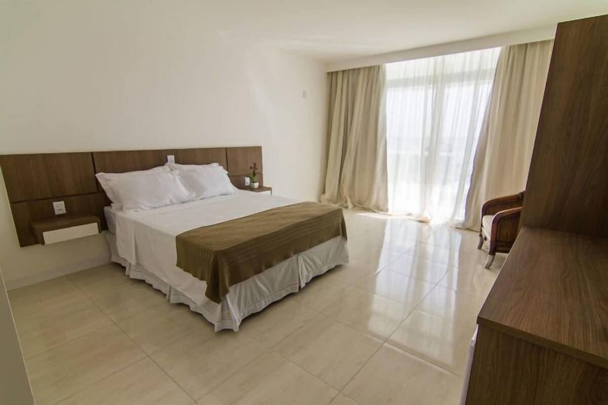 Una habitación de hotel con cama, mesita de noche, escritorio y silla.