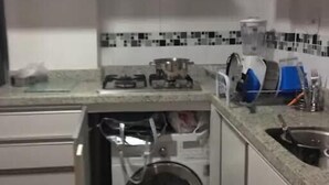 Une cuisine compacte équipée d’un lave-vaisselle intégré, d’une cuisinière et d’un four à micro-ondes.